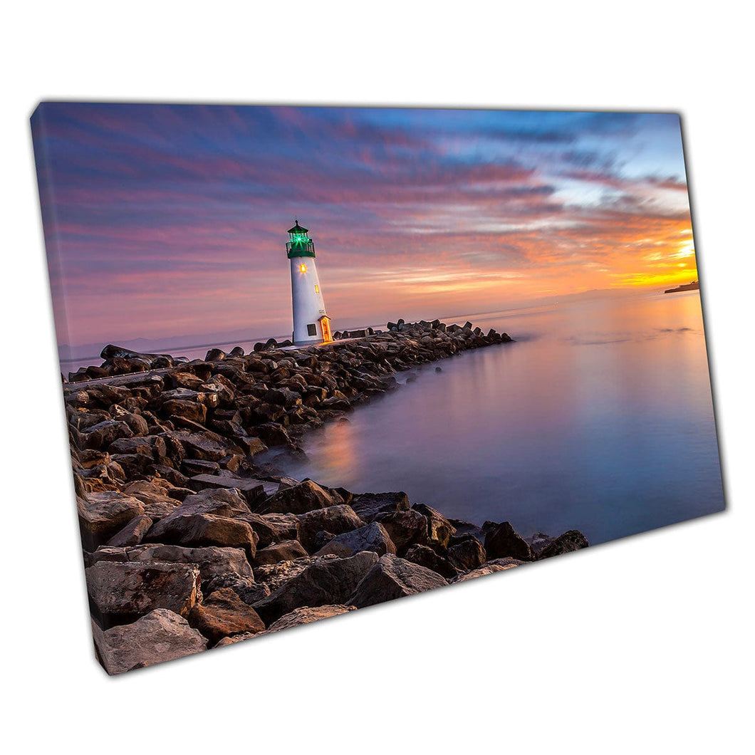 White Lighthouse Standing At The End Of A Rocky Curved Pier During An Ocean Sunset Wall Art Print On Canvas Mounted Canvas print
