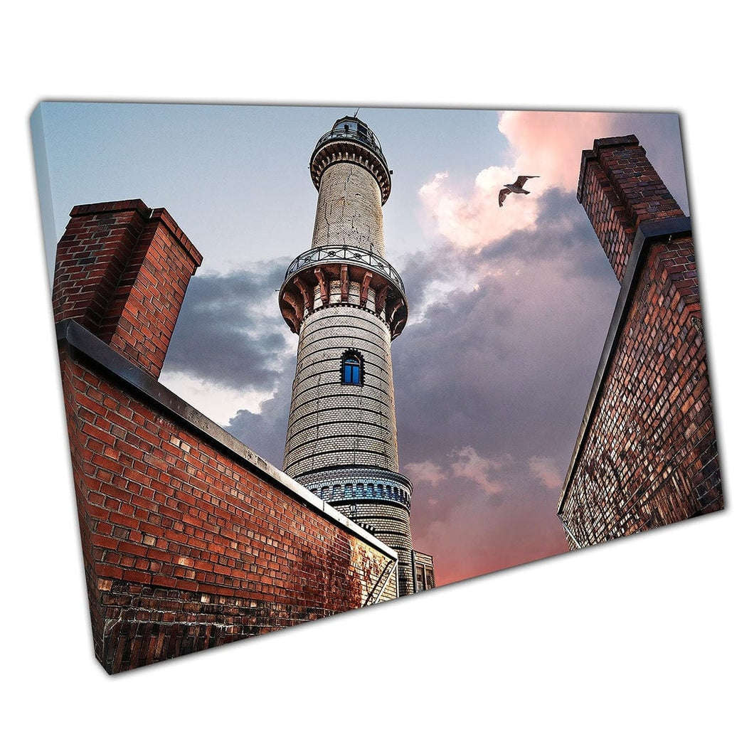 Weathered Lighthouse Under Dramatic Fiery Sky With A Seagull Passing Through Rostock Wall Art Print On Canvas Mounted Canvas print